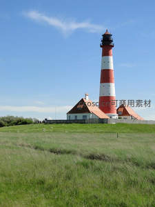 绿野上的红白灯塔与羊群