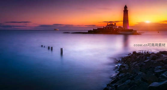 日落时分灯塔剪影映霞光