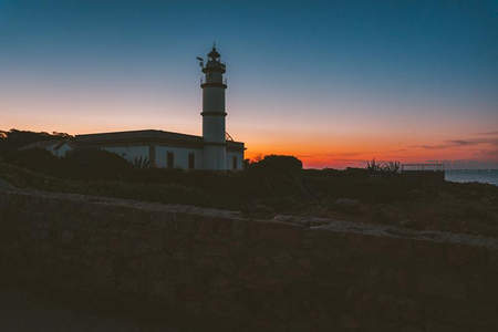 落日熔金，灯塔剪影伴晚霞