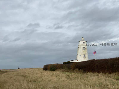 白色灯塔旁飘扬着英国国旗