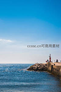 晴空碧海旁的码头灯塔