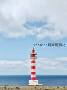 红白条纹灯塔矗立海岸，云海相接