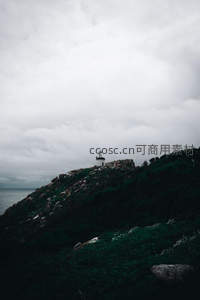 阴云密布中孤寂灯塔守望山巅