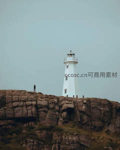 悬崖峭壁上，白色灯塔与人影相伴