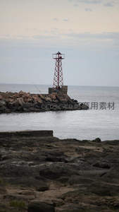 红架灯塔矗立礁石，渔人垂钓伴海风
