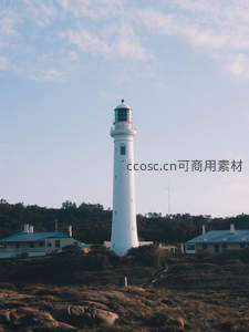 纯白灯塔耸立山丘，绿树环绕显宁静