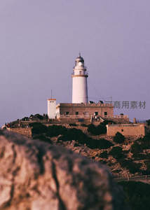 山顶灯塔在暮色中的庄严剪影