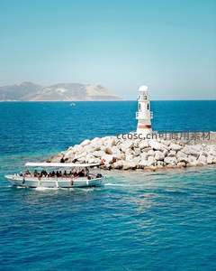 碧海蓝天下的白色灯塔与观光船