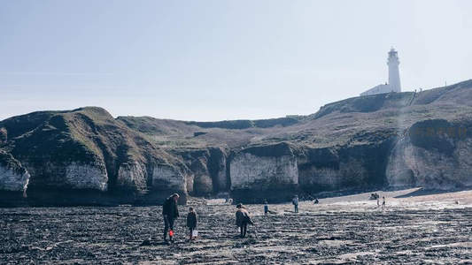 悬崖海滩游人远眺灯塔