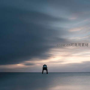 孤灯塔立于暮色海面，云层低垂如画