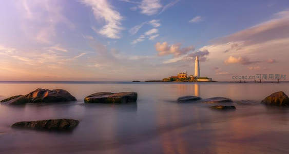 夕阳下白色灯塔倒影于柔光海面