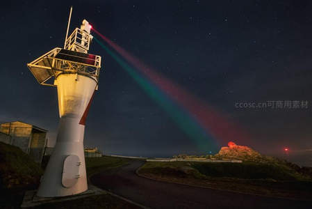 夜空下灯塔射出彩色激光束，星光点点
