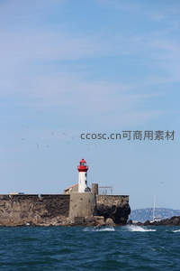 红顶灯塔旁飞鸟掠过碧海