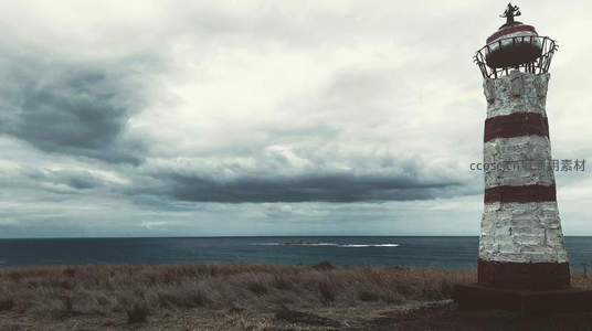 风暴云下斑驳灯塔，海边荒草见证岁月