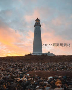 夕阳下白色灯塔辉映彩霞