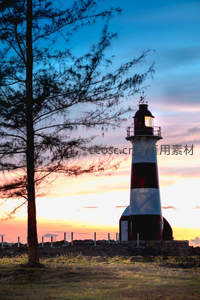 日落时分灯塔剪影映衬绚丽晚霞