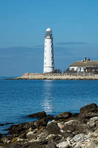 碧海蓝天中洁白灯塔倒影如画