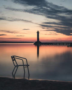 暮色孤椅映衬灯塔剪影