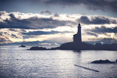 云海波涛间孤岛灯塔剪影如诗如画