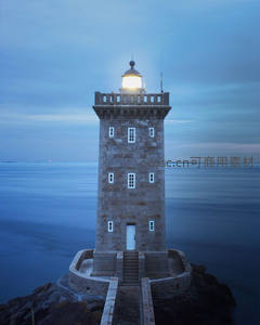 暮色中亮灯的石砌灯塔