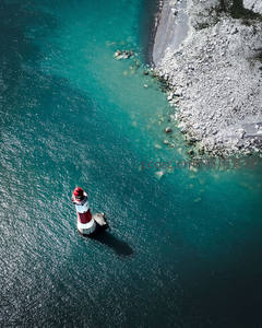 俯瞰碧海中的红白条纹灯塔