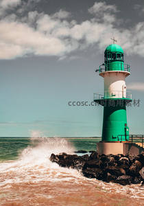 碧绿灯塔守卫礁石，巨浪拍岸水花四溅