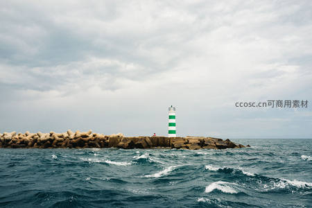 绿白灯塔守望波涛汹涌海堤