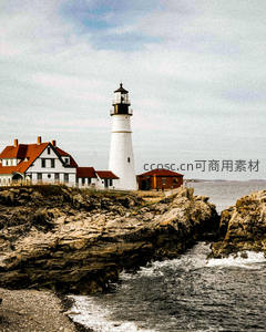 岩石海岸上的经典灯塔，红顶白墙映衬海浪