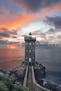 日落时分岩石上的古老石灯塔