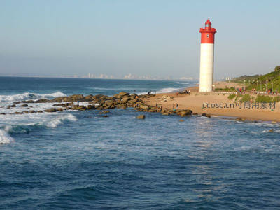 海边红顶灯塔与远处城市天际线