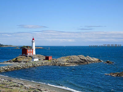 红白灯塔矗立海岸礁石之上