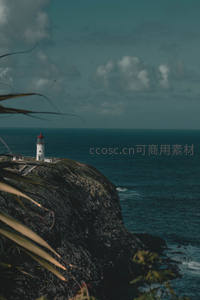 悬崖之巅的白色灯塔与深蓝大海