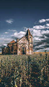 田野中孤寂废弃教堂与多云天空