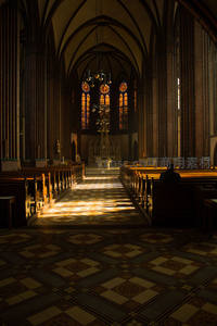 阳光穿透彩窗洒在教堂长廊地面