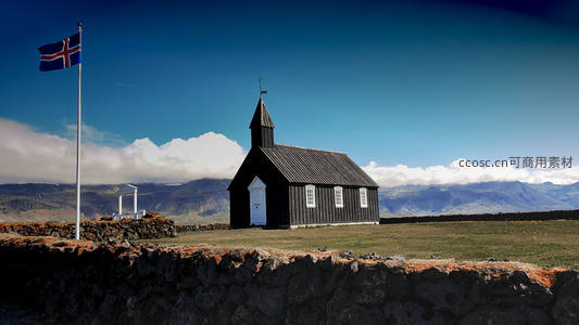 冰岛黑教堂与飘扬国旗的壮丽山景