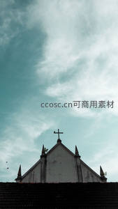 云影下的古老教堂屋顶与十字架剪影