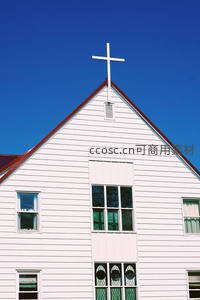 蓝天下的白色教堂尖顶与十字架