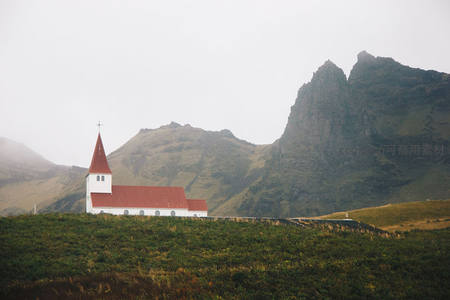 山峦环抱中红顶白墙小教堂的宁静风景