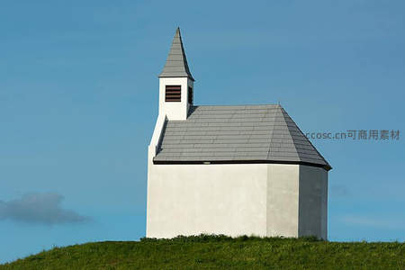 白墙小教堂孤立山丘，蓝天为幕