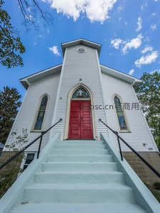 白色教堂红门映蓝天，阶梯通向神圣之境