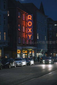 夜晚街道旁橙色霓虹“ROXY”招牌照亮街景