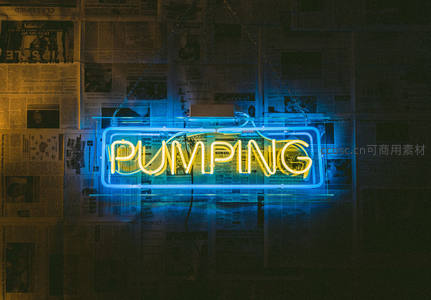 蓝黄双色霓虹灯‘PUMPING’悬于报纸墙前