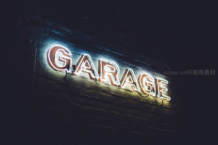 砖墙上的白色霓虹GARAGE标志