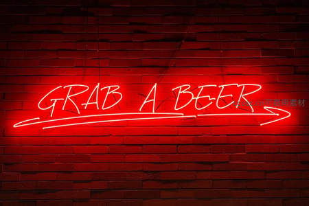 红色霓虹灯牌‘GRAB A BEER’照亮砖墙
