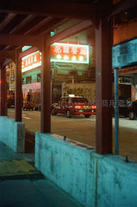 街角霓虹招牌下的红色出租车