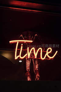 红色霓虹灯勾勒出Time字样，背景人影朦胧