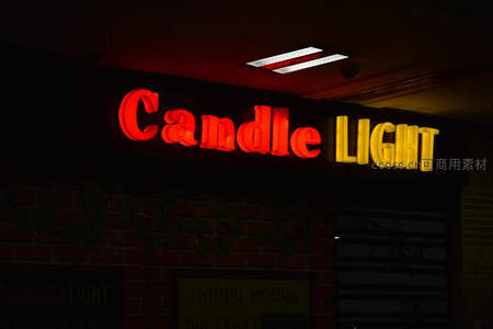 红色与黄色霓虹字点亮酒吧门面
