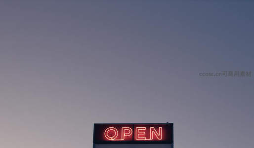 暮色中一盏红色OPEN霓虹灯
