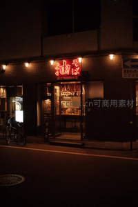 日式拉面店夜景，红色招牌映衬街角温情