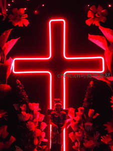 红色霓虹十字架在花丛中散发神圣光芒